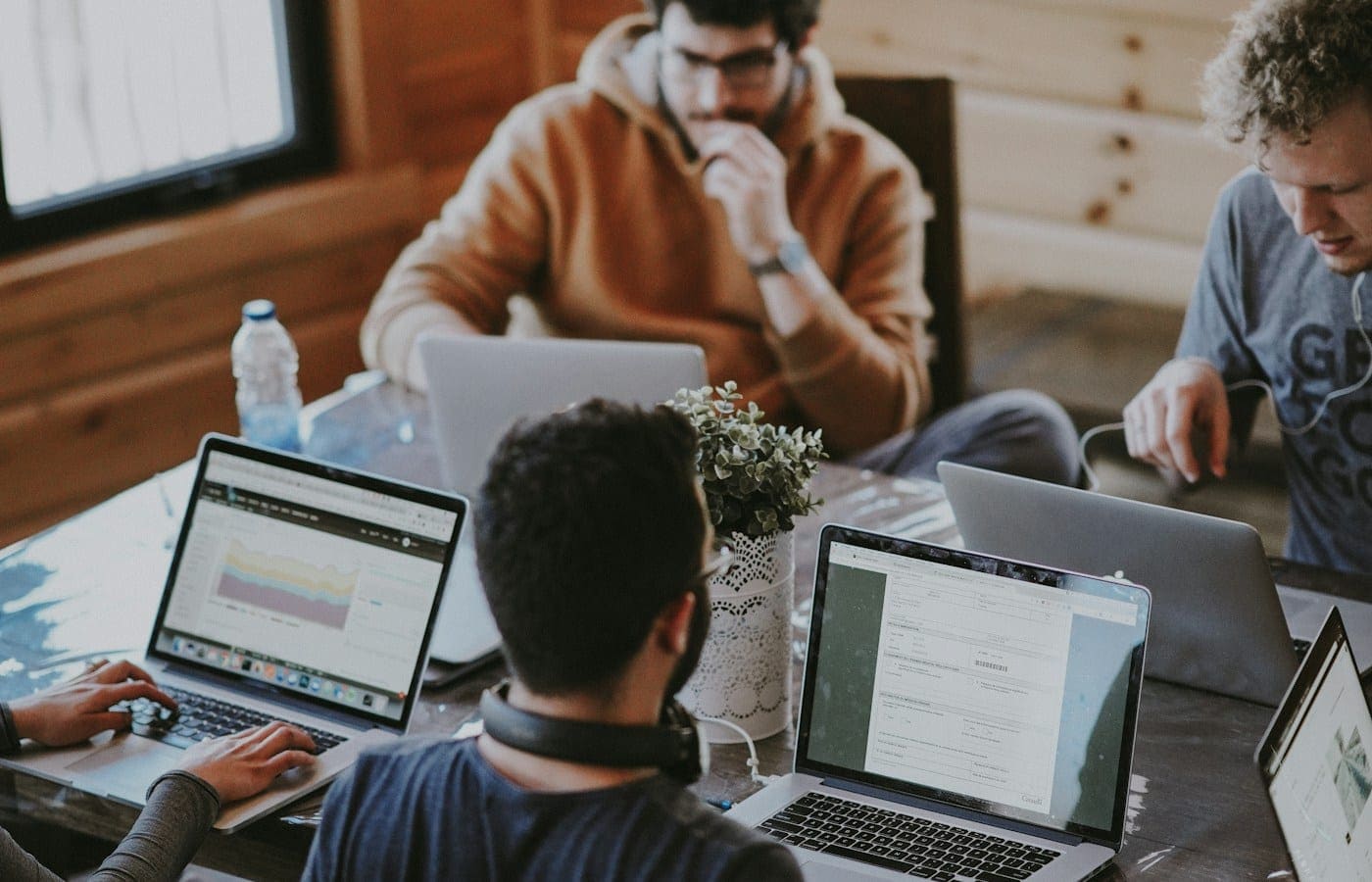 Équipe réunie autour d'une table de travail avec des ordinateurs